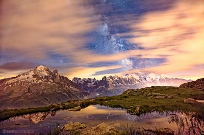 Photo du Mont-Blanc sous la Voie Lactée, ainsi que son reflet dans un lac de Montagne. Photographie des Alpes de Lionel Caracci, qui expose par ailleurs ses Décorations murales dans sa Galerie d'art à Lyon 2.