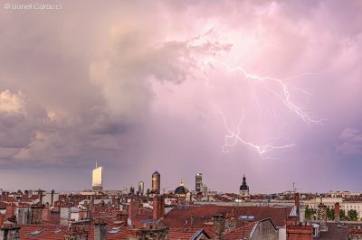 Photo de Lyon sous l'orage, ainsi qu'un gros éclair ramifié derrière Part-Dieu. Photographie de Lyon de Lionel Caracci, qui expose par ailleurs ses Décorations murales dans sa Galerie d'art à Lyon 2.