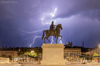 Photo de la Statue de Louis XIV à cheval Place Bellecour à Lyon, ainsi que la foudre qui tombe lors d'un Orage. Photographie de Lyon de Lionel Caracci, qui expose par ailleurs ses Décorations murales dans sa Galerie d'art à Lyon 2.